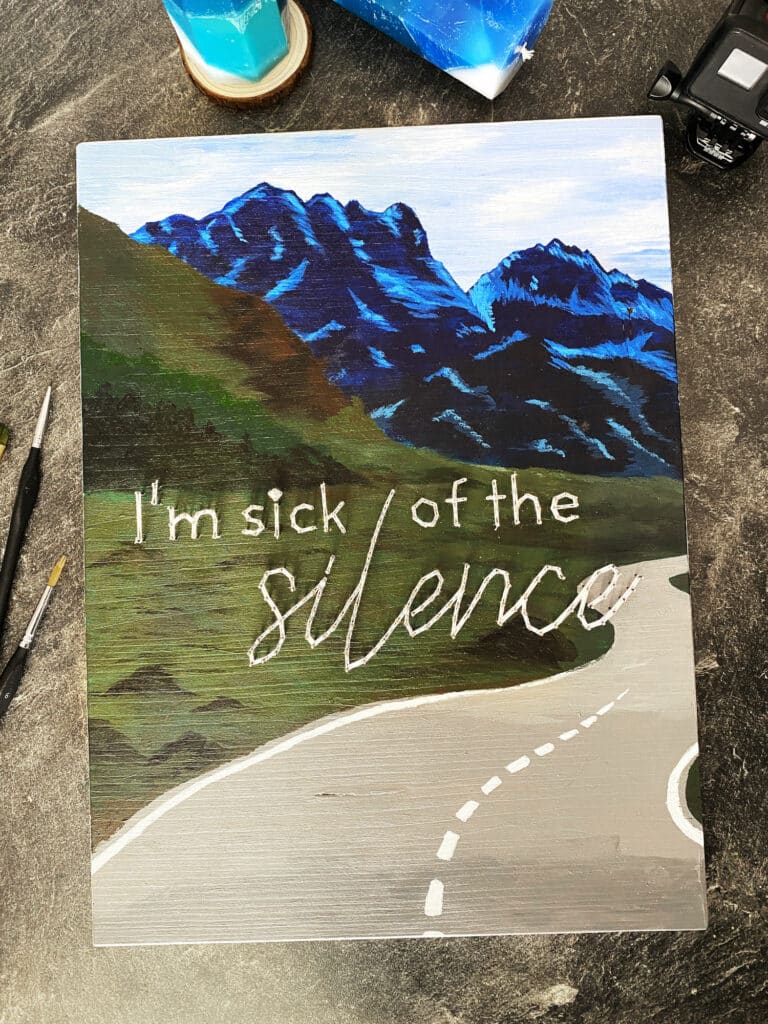 Gemaltest Bild mit Bergiger Landscahft und einer verlassen Straße mit Schrift I'm sich of the Silence