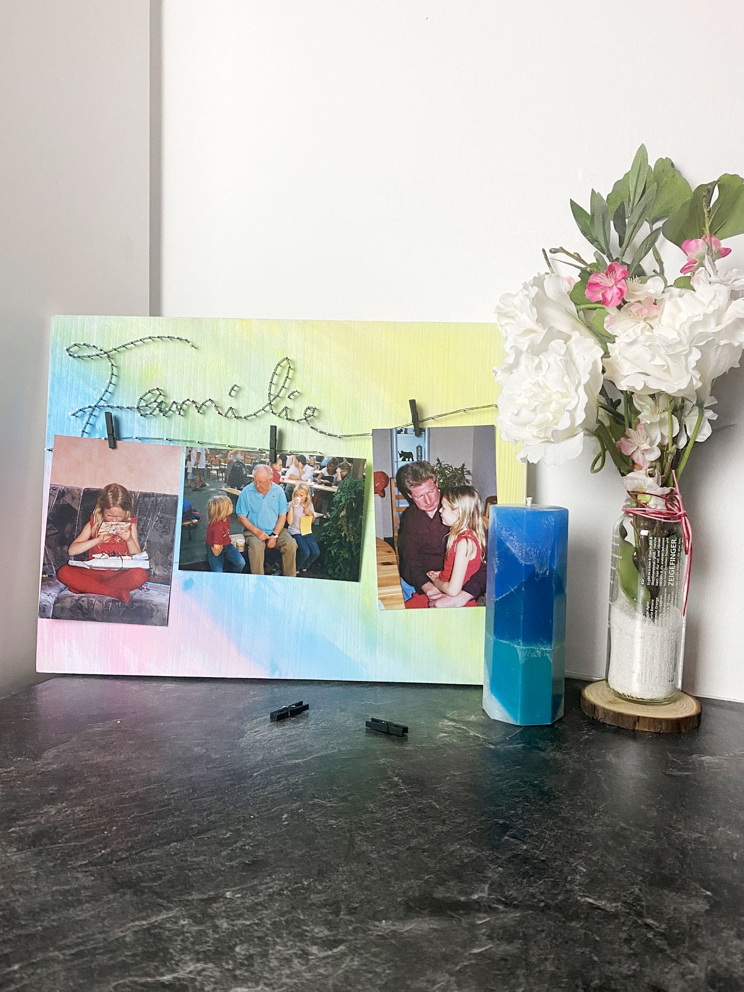 Fadenbild Familie mit Familien-Fotos und Blumen und Kerze als Deko.